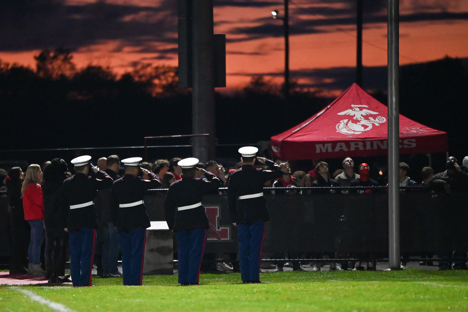 Marines saluting the flag during the National Anthem