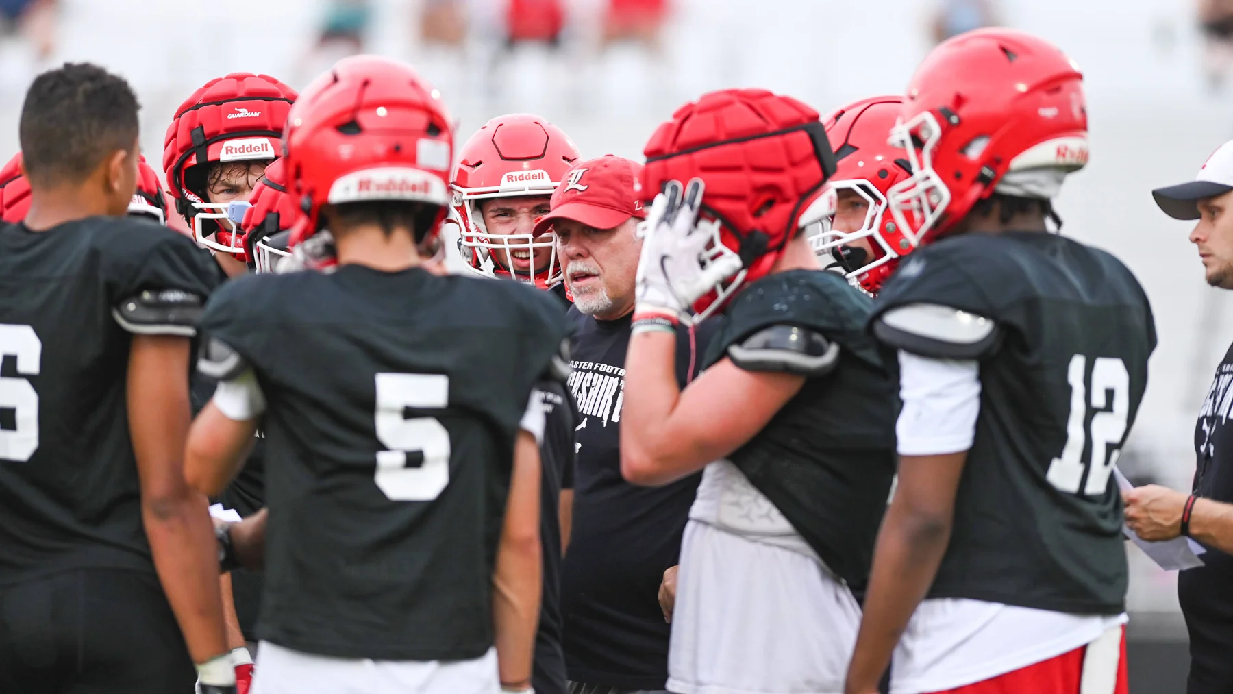 Coach in the middle of the huddle